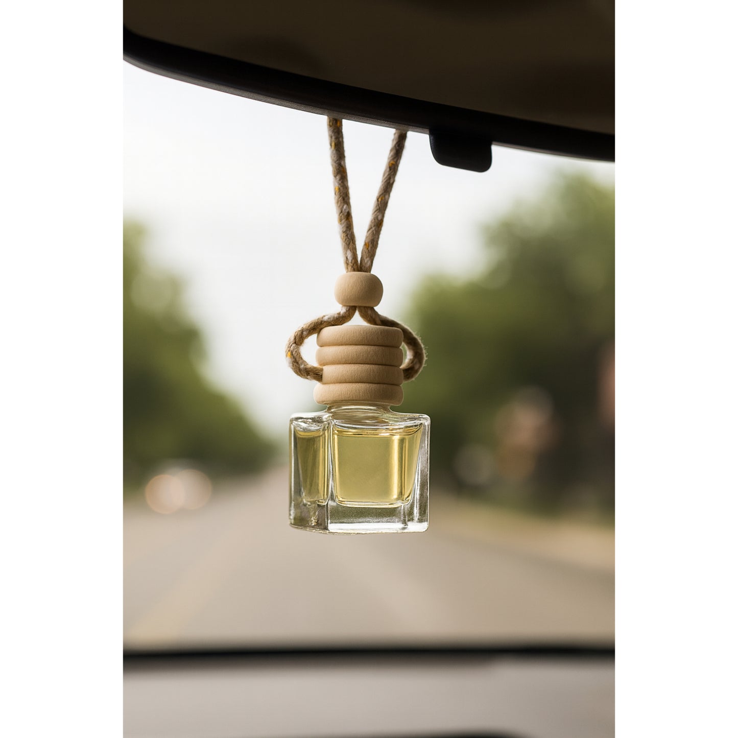 Cozyees clear glass car dffuser hanging on rearview mirror.