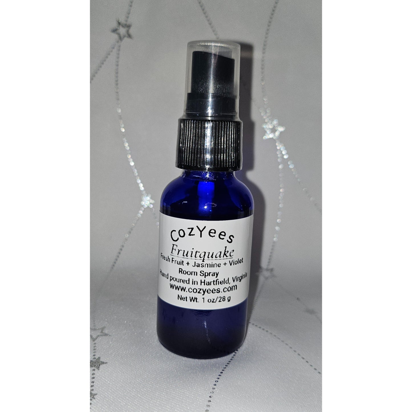 Blue spray bottle with a white label on a textured gray background