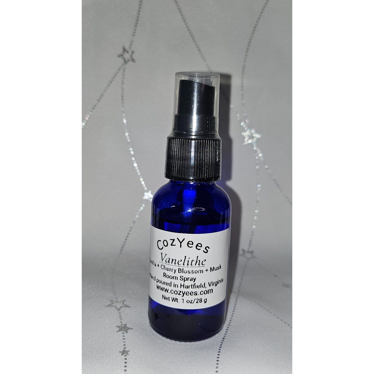 Blue spray bottle with a white label on a textured gray background