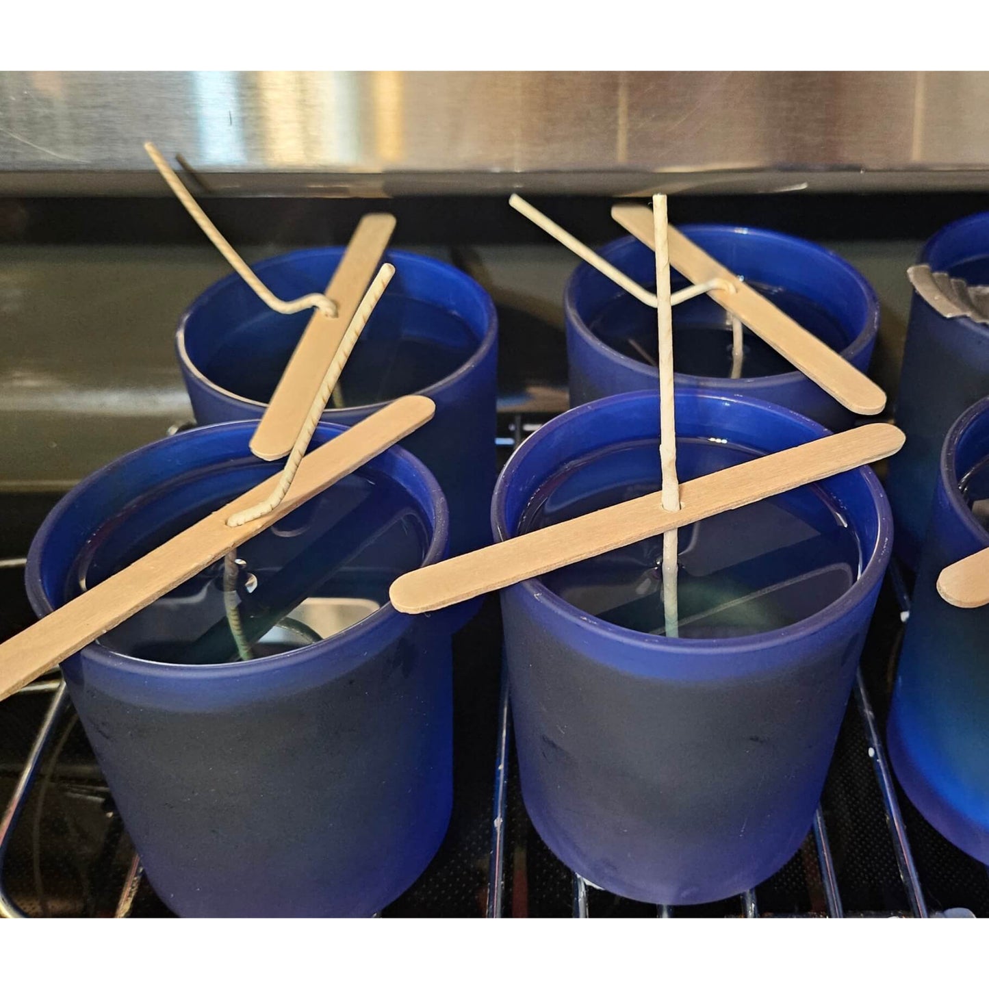 Blue cups with wooden sticks in a sink