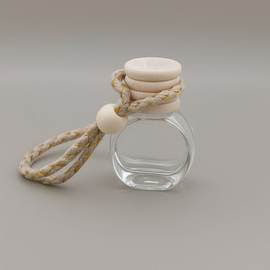 Cozyees small glass bottle with a beige cap and rope on a gray background