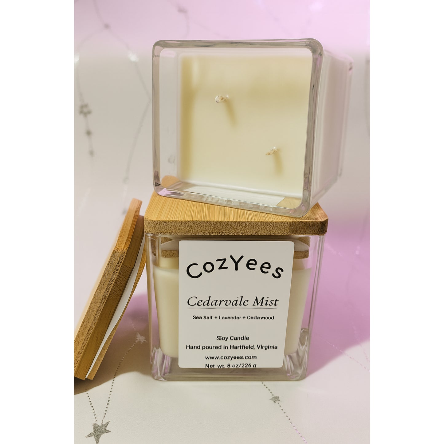 Cozyees Cedarvale Mist candle in a clear container with a wooden lid on a white surface.