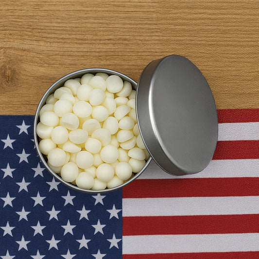 Open metal tin filled with white candies on an American flag background