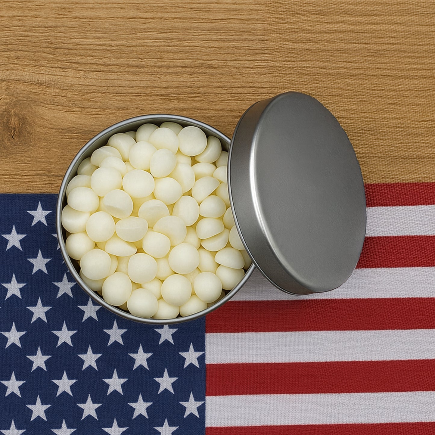 Open metal tin filled with white candies on an American flag background