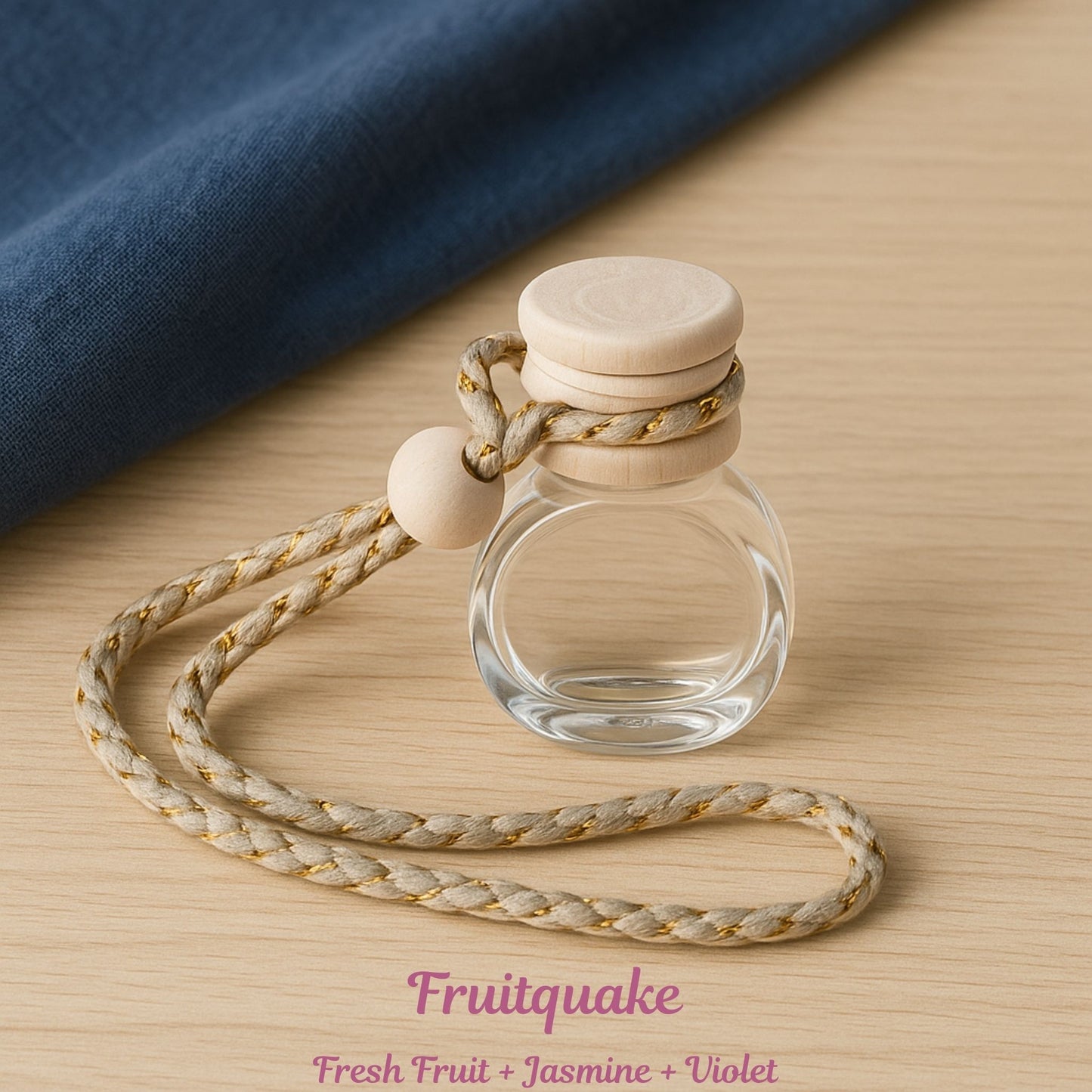 Small glass bottle with wooden cap and rope on a wooden surface, labeled 'Fruitquake'.