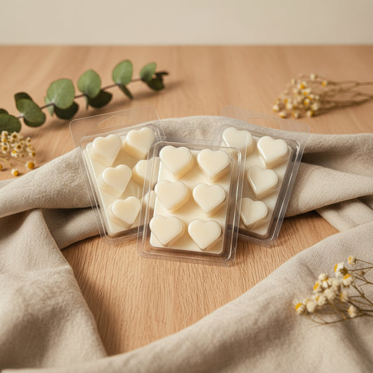 Heart-shaped wax melts in a clear plastic packaging on a light gray background with star patterns.