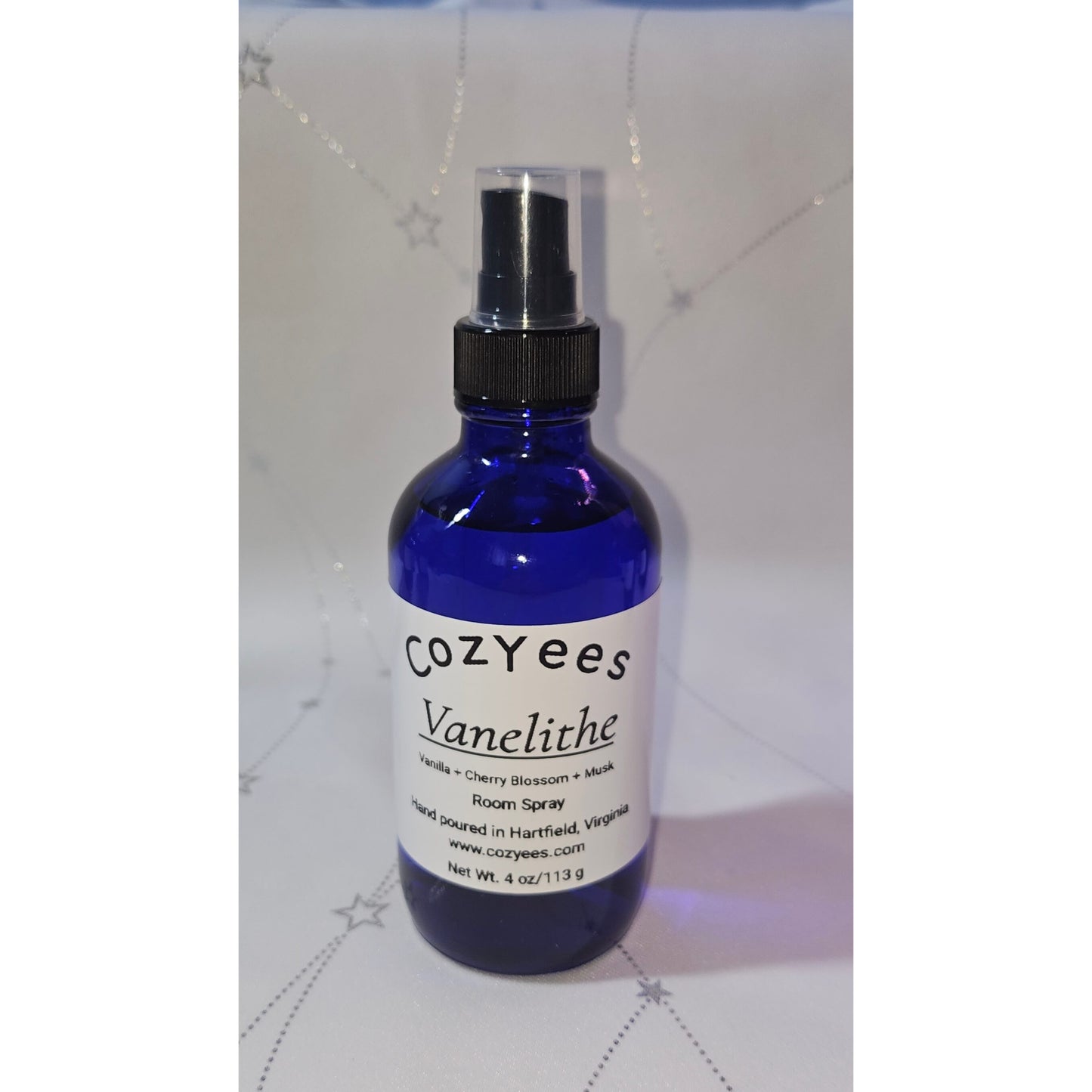Blue spray bottle labeled 'Cozyees' on a white background