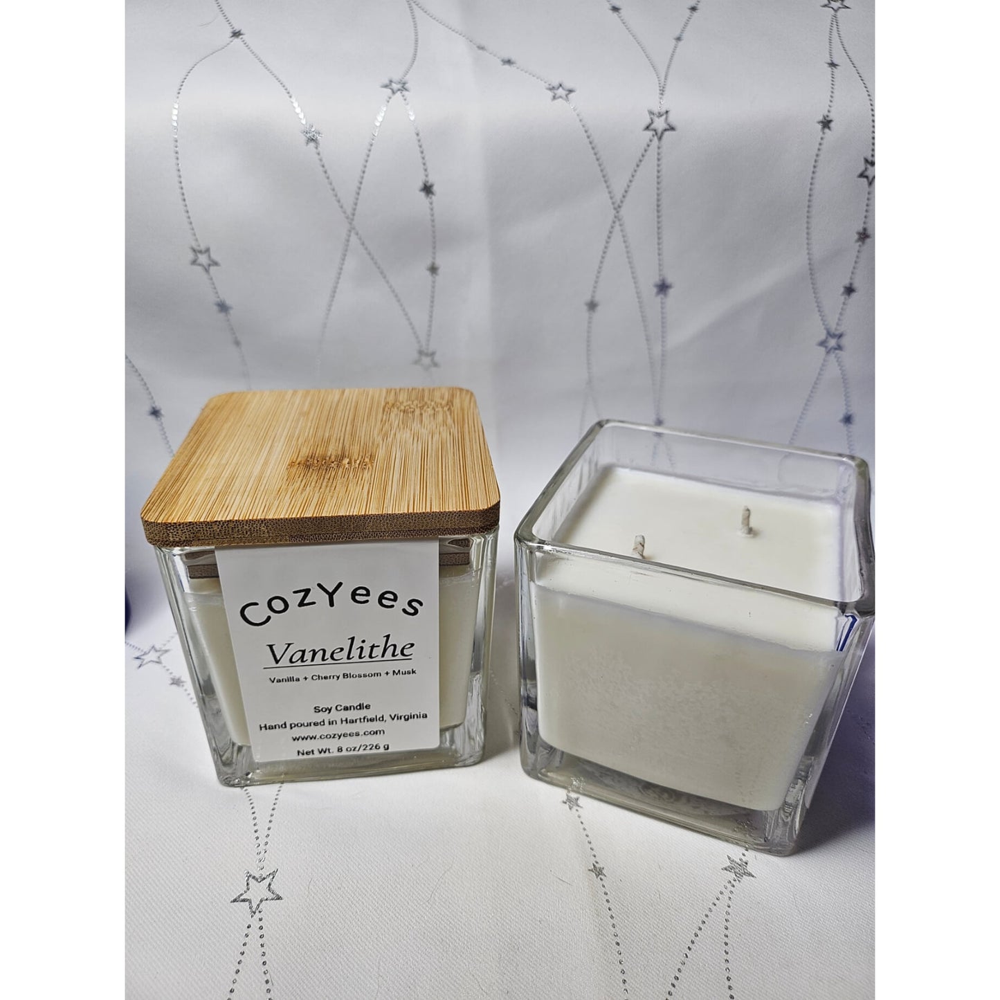 Cozyees candle with wooden lid on a decorative background