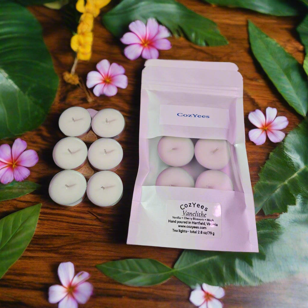 Tea lights in a Cozyees packaging on a dark background with colorful plants