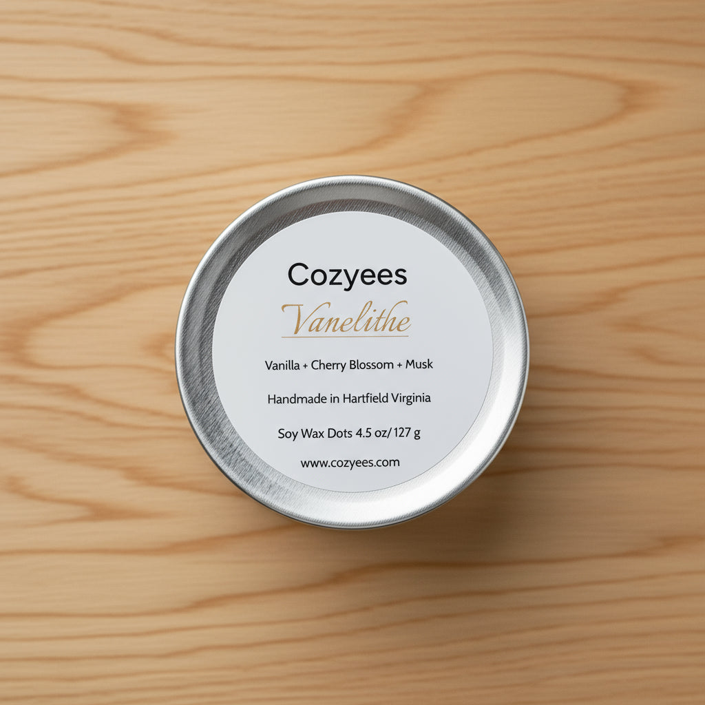Cozyees Vanelithe candle tin lid with product details on a gray background