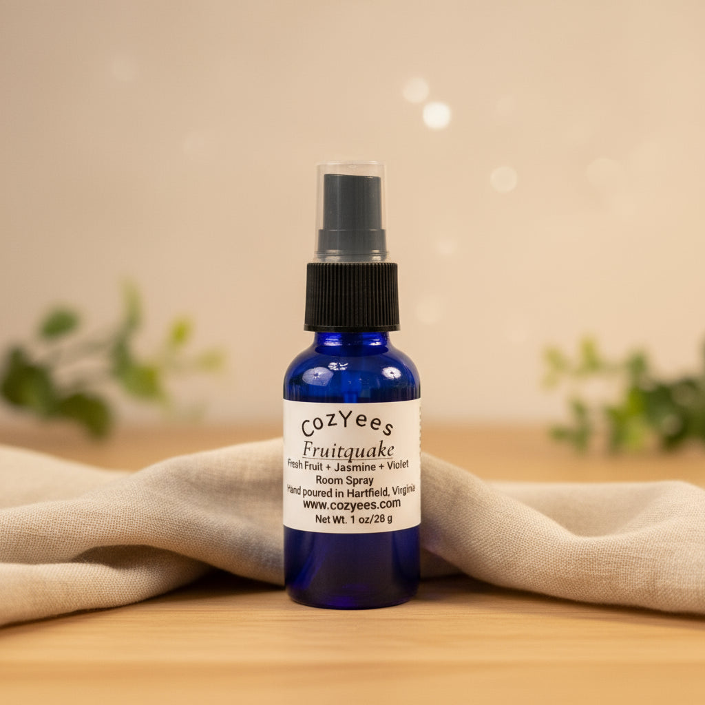 Cozyees Fruitquake room spray bottle on a wooden surface with a soft focus background