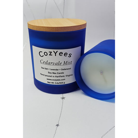CozYees Cedarale Mist candle with blue container and wooden lid on a white background