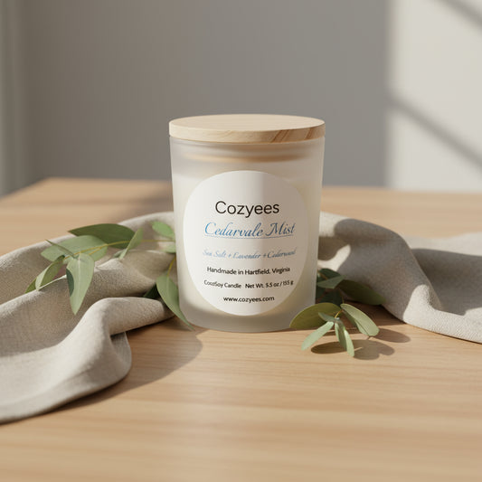 Candle with wooden lid labeled 'Cozyees Cedarvale Mist' on a gray background