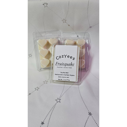Packaged Cozyees Fruitquake wax melts on a star-patterned background