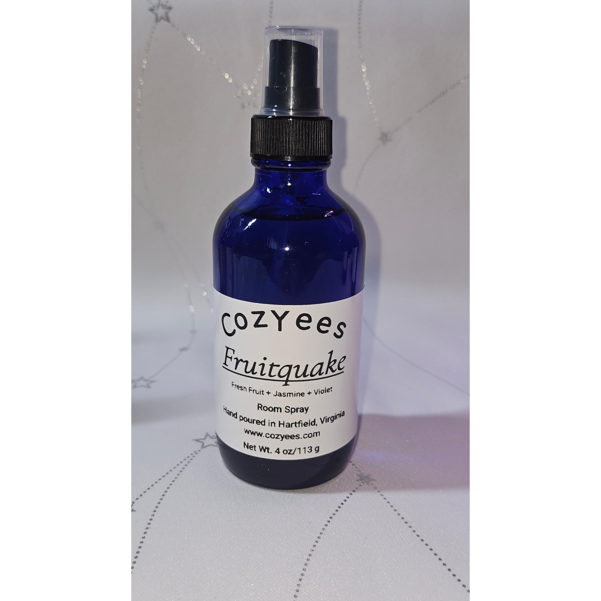 Blue spray bottle labeled 'Cozyees Fruitquake' on a white background