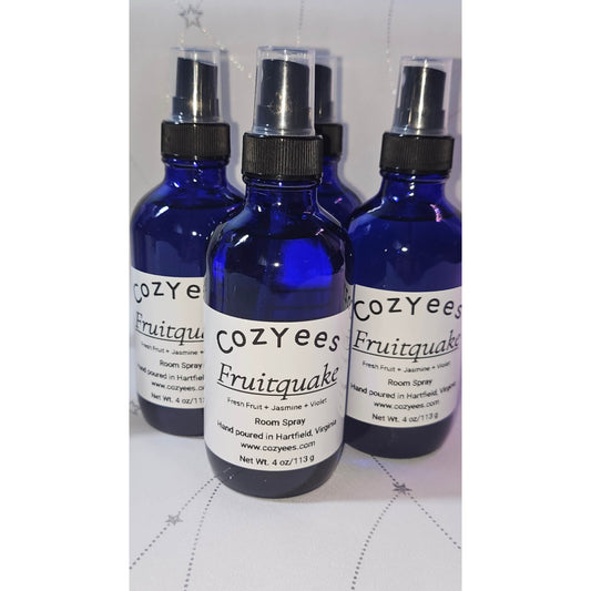 Three Cozyees Fruitquake room spray bottles on a white surface.