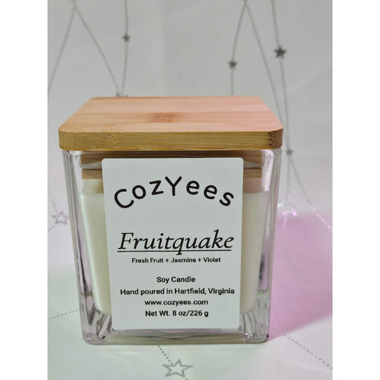 Cozyees Fruitquake candle with wooden lid on a light background