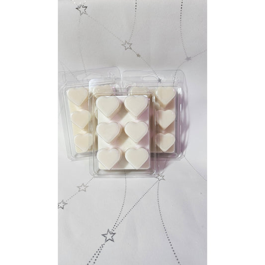 Heart-shaped wax melts in a clear plastic packaging on a light gray background with star patterns.