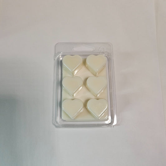 Pack of heart-shaped wax melts in clear packaging on a light gray background