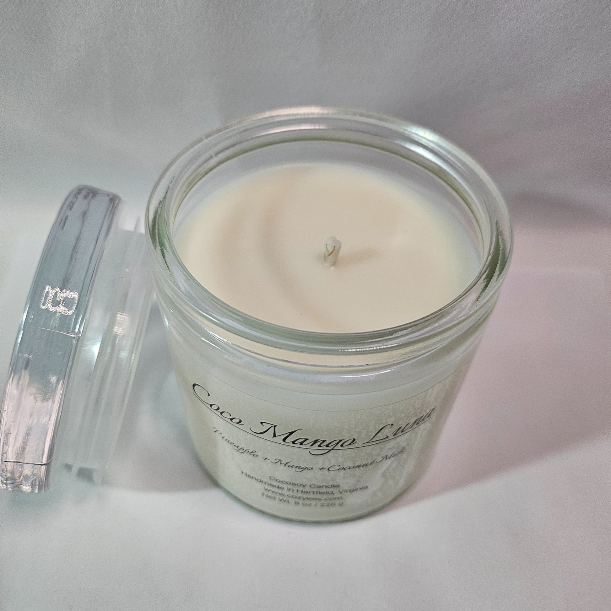 Candle in a glass jar with a label on a white background