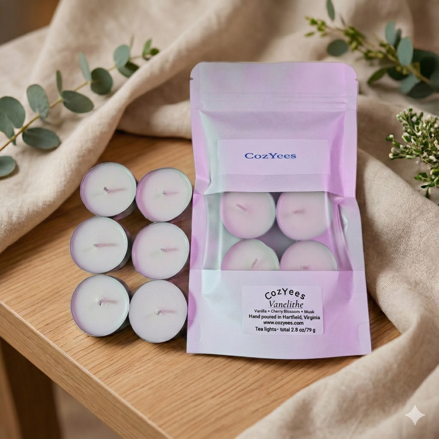 Cozyees tealights in a 6 pk on a wood table
