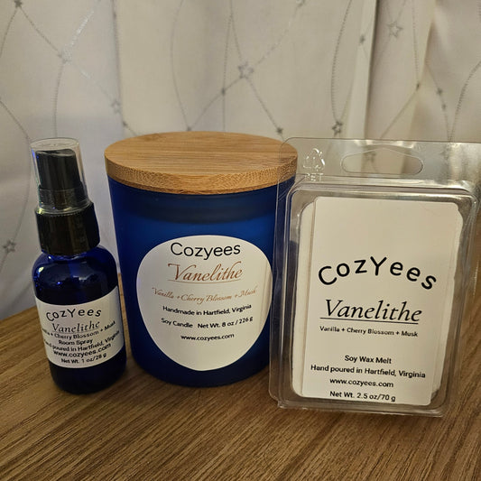 Cozyees Vanelithe candle, spray bottle, and wax melt on a wooden surface with a neutral background.