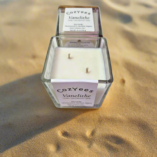Cozyees Vanelithe candle in a glass container on sand