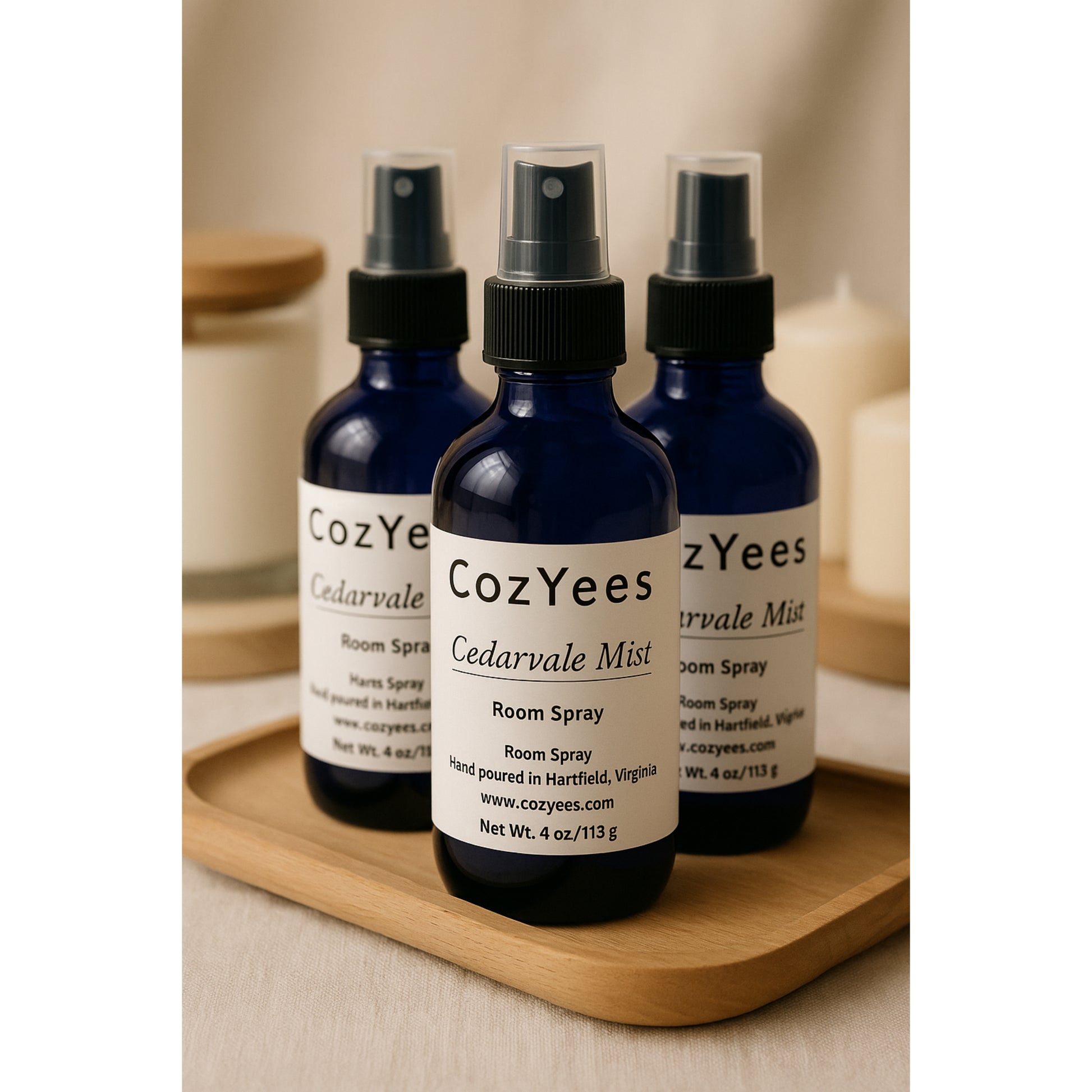 Three CozYees Cedarvale Mist room spray bottles on a wooden tray.