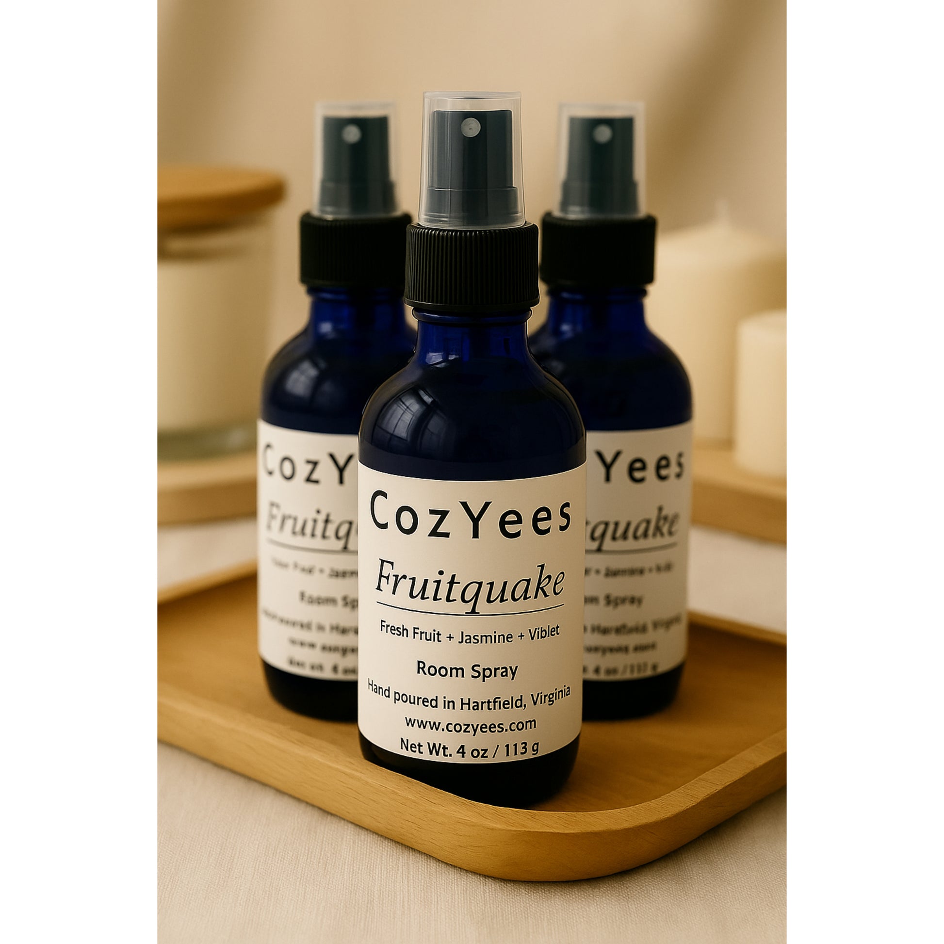Three CozYees Fruitquake room spray bottles on a wooden tray.