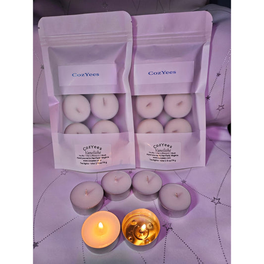 CozYees candles in packaging on a purple surface with two lit candles.