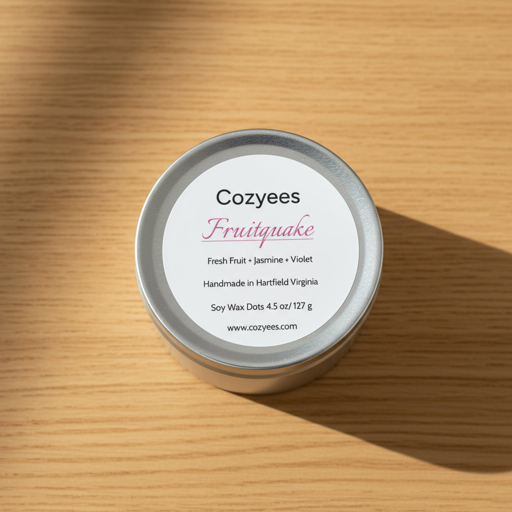 Cozyees Fruitquake candle tin lid with product details on a gray background