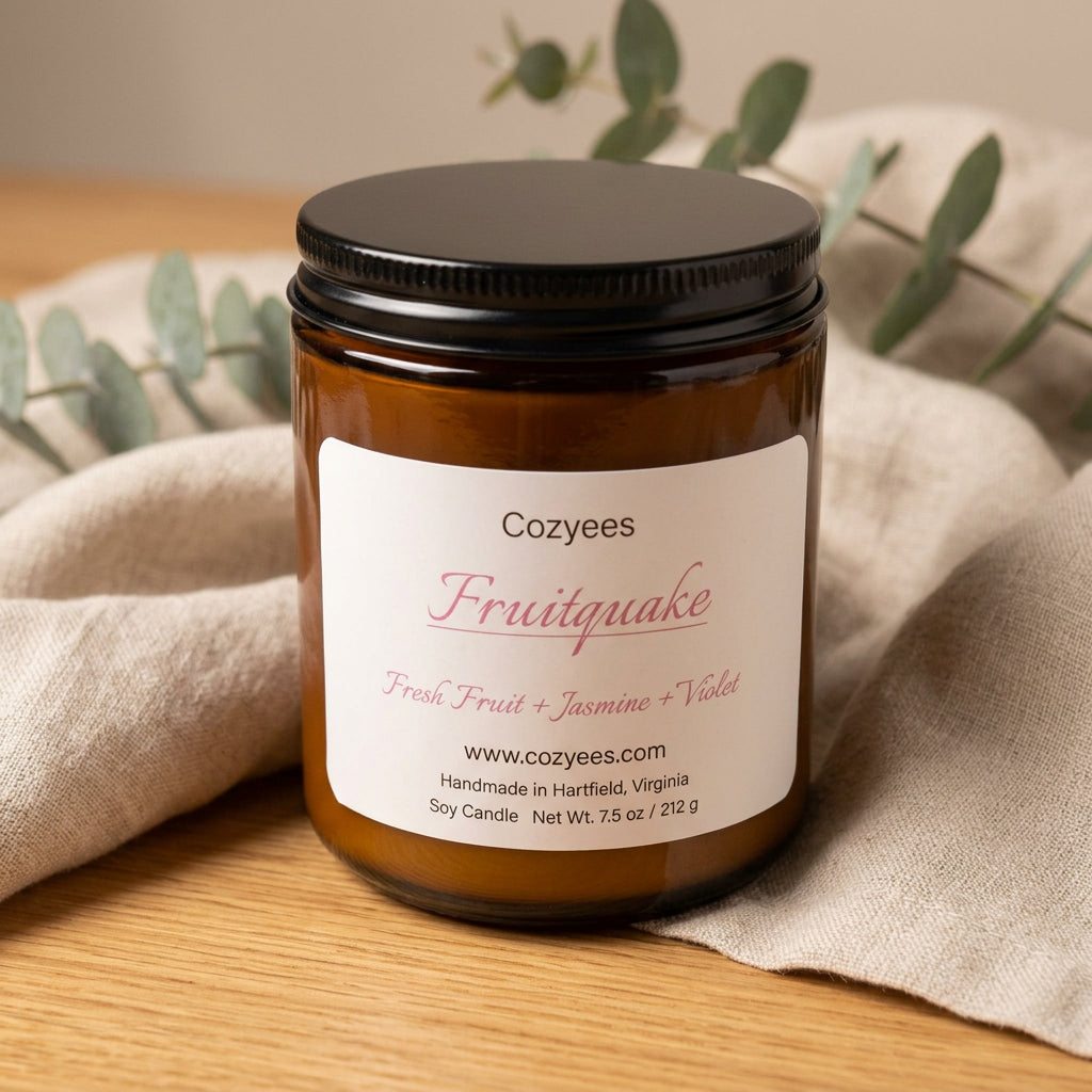 Cozyees Fruitquake 7.5 oz soy candle in an amber glass jar with a black lid