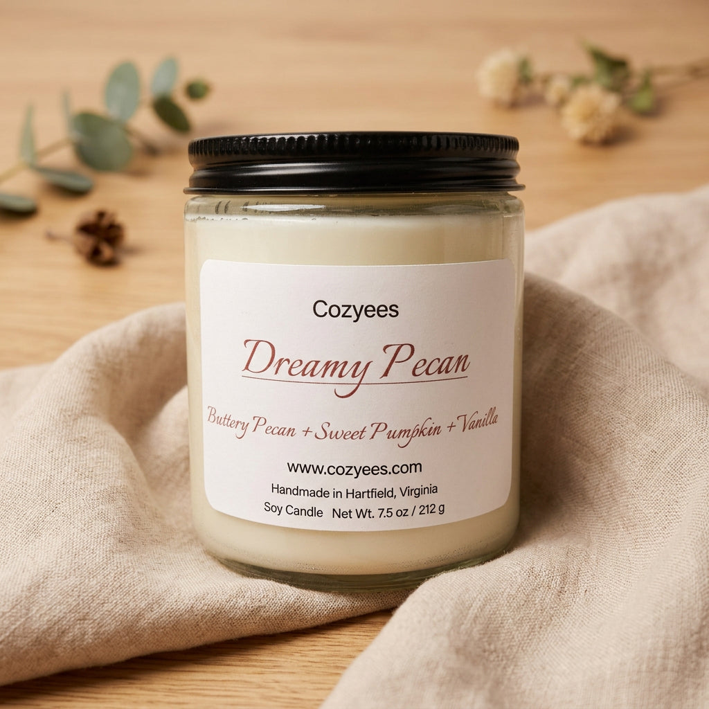 Cozyees Dreamy Pecan 7.5 oz soy candle in a clear glass jar with a black lid