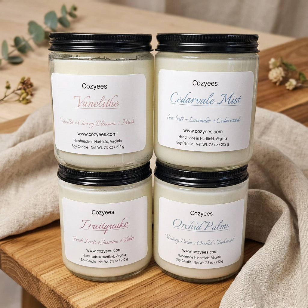 Four clear glass Cozyees soy candles stacked: Vanelithe, Cedarvale Mist, Fruitquake and Orchid Palms