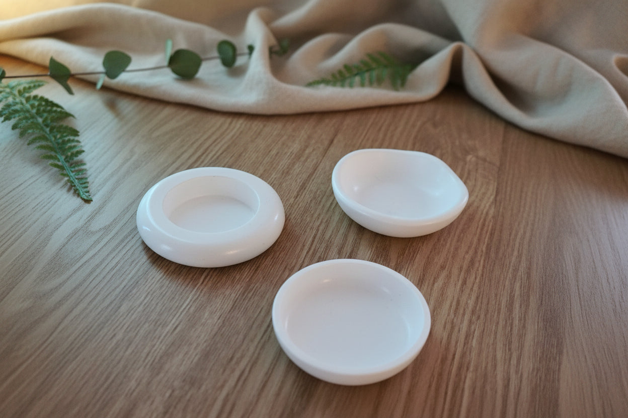 Three white ceramic bowls on a wooden surface